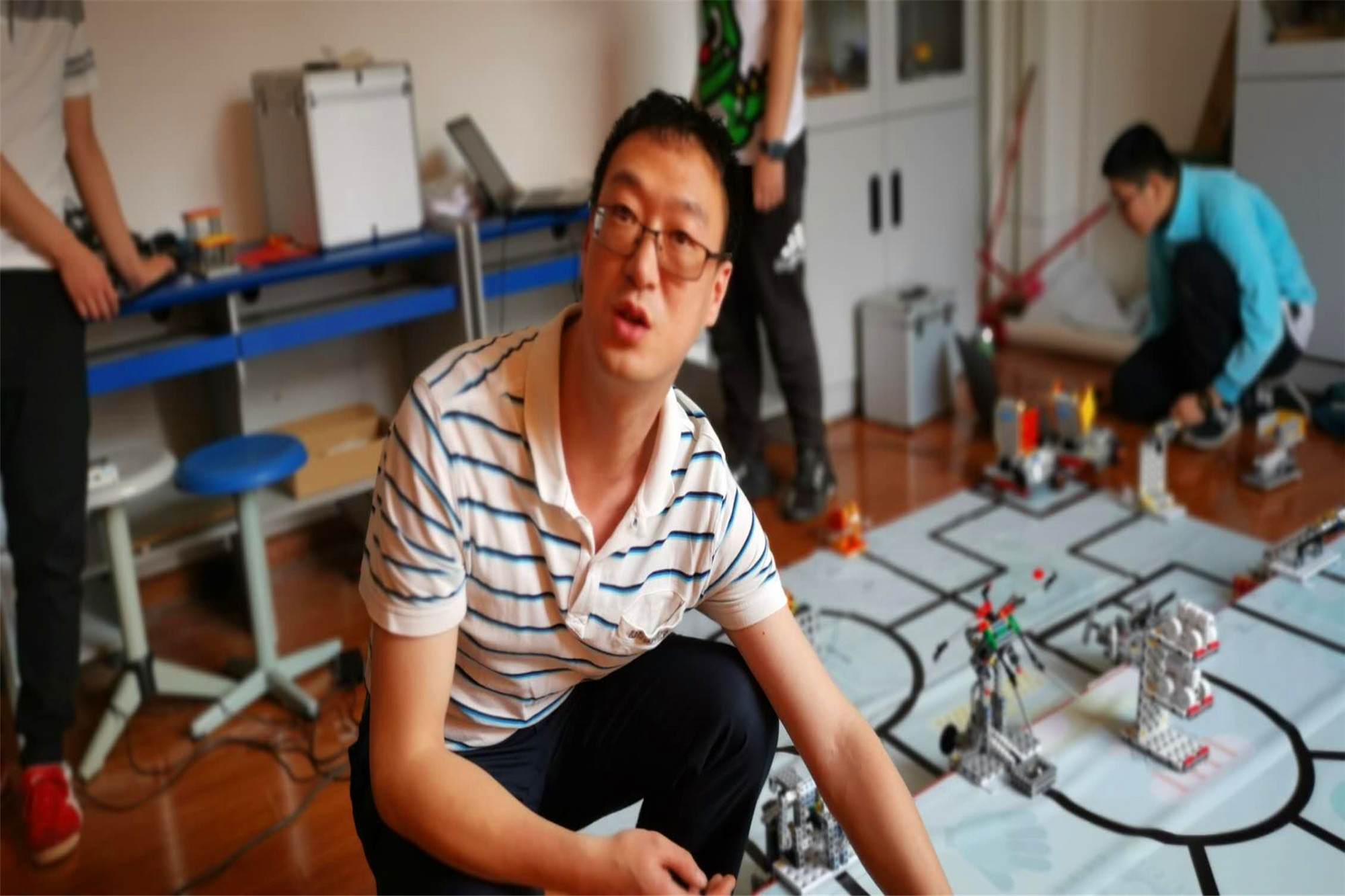 指導教師在指導學生操作機器人。